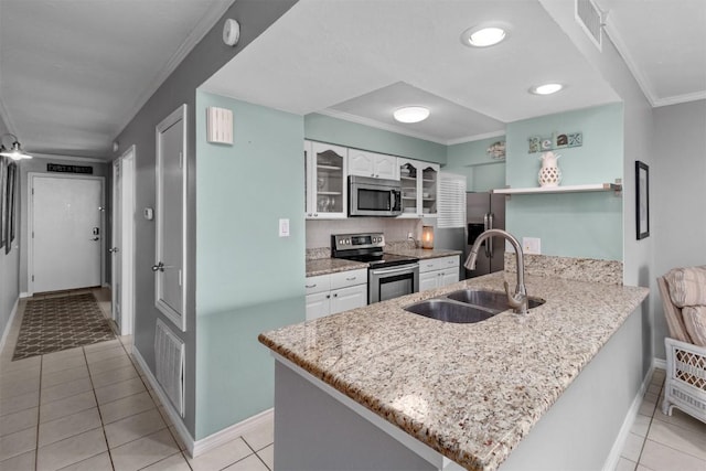 12500 Melville Dr Unit 143D, Montgomery, TX 77356 - kitchen featuring stainless steel appliances, a peninsula, white cabinets, glass insert cabinets, and light tile patterned flooring