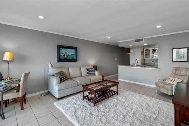 living room featuring light tile patterned floors, ornamental molding, and sink