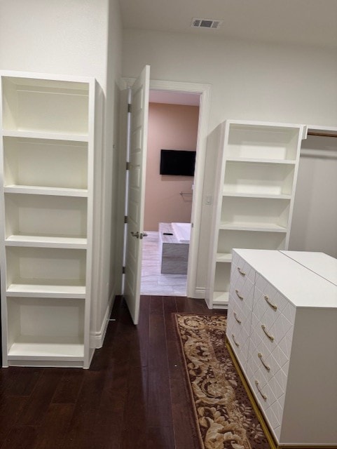 spacious closet featuring dark hardwood / wood-style floors