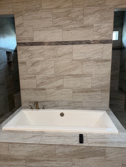 bathroom featuring tiled tub