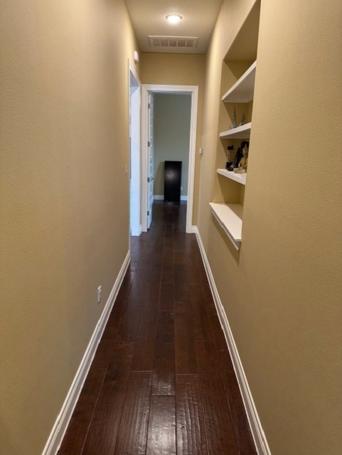 hall with dark hardwood / wood-style floors and built in shelves