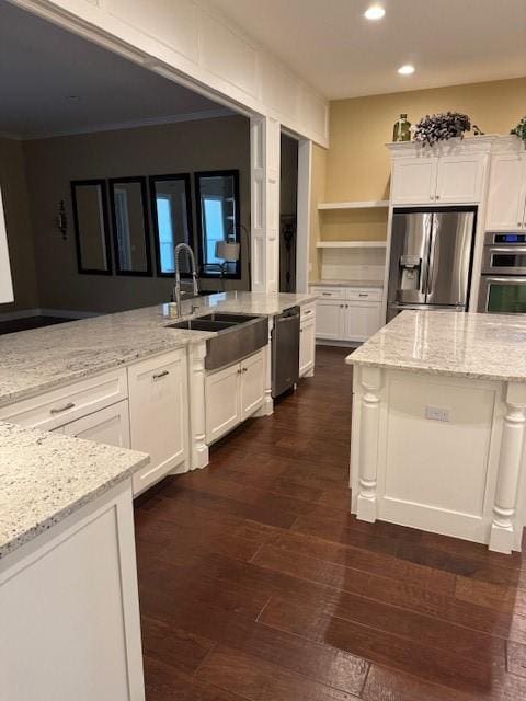 kitchen with stainless steel appliances, sink, white cabinets, and light stone counters