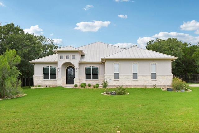124 Abamillo Dr, Bastrop, TX 78602 - view of front facade featuring a standing seam roof, stucco siding, and a front lawn