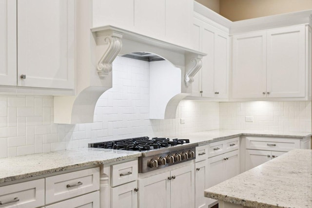 124 Abamillo Dr, Bastrop, TX 78602 - kitchen with stainless steel gas cooktop, white cabinets, decorative backsplash, and light stone countertops