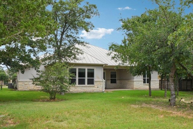 124 Abamillo Dr, Bastrop, TX 78602 - rear view of house featuring stone siding, a standing seam roof, stucco siding, and a metal roof