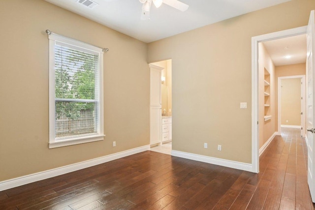 124 Abamillo Dr, Bastrop, TX 78602 - empty room with a ceiling fan, dark wood-style floors, and built in features