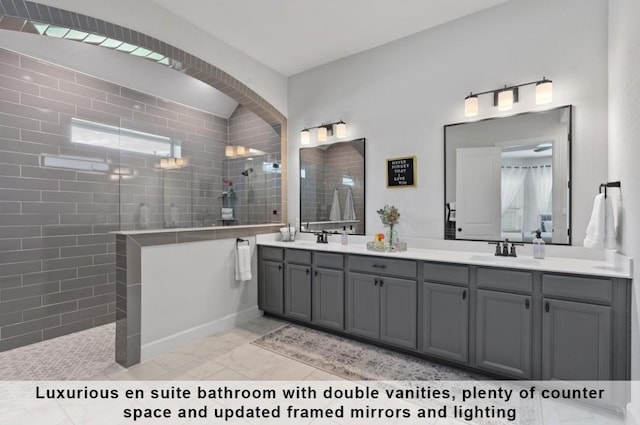 bathroom with tiled shower and vanity