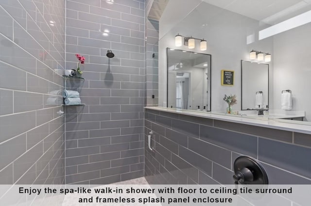 bathroom featuring tiled shower and vanity