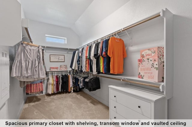 walk in closet with light carpet and vaulted ceiling