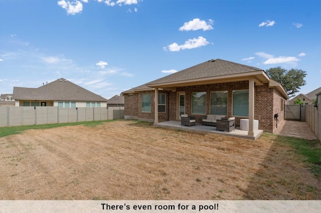 back of property with outdoor lounge area, a yard, and a patio area