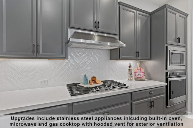 kitchen featuring tasteful backsplash, appliances with stainless steel finishes, and gray cabinets