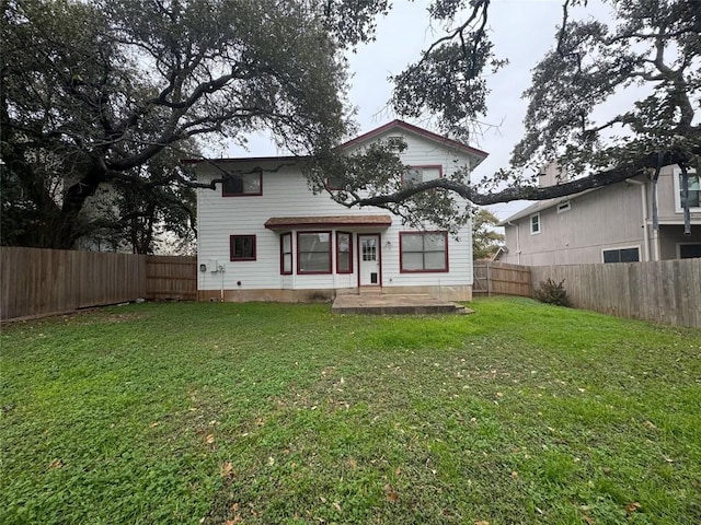 back of house featuring a patio and a lawn