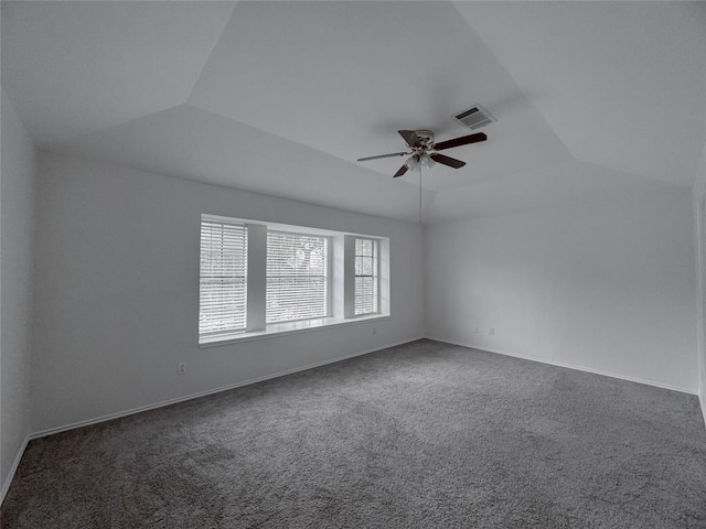 spare room with lofted ceiling, ceiling fan, and dark colored carpet