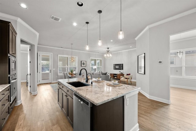 kitchen with a sink, light wood finished floors, stainless steel appliances, and visible vents