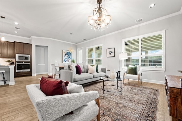 living area featuring an inviting chandelier, light wood-style flooring, baseboards, and visible vents