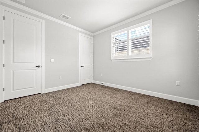 unfurnished bedroom with baseboards, ornamental molding, carpet flooring, and visible vents