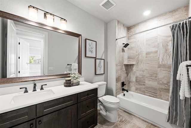 bathroom featuring vanity, toilet, visible vents, and shower / bath combo