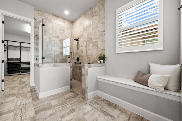 full bath with walk in shower, a wealth of natural light, and baseboards