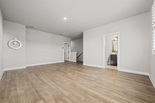 unfurnished living room featuring light wood-type flooring, visible vents, and baseboards