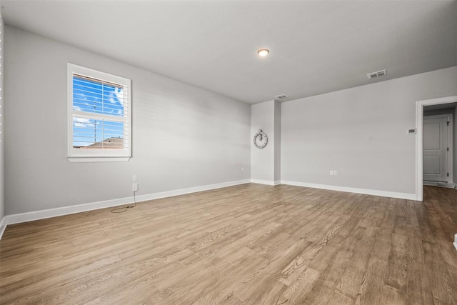 unfurnished room with light wood-type flooring, baseboards, and visible vents