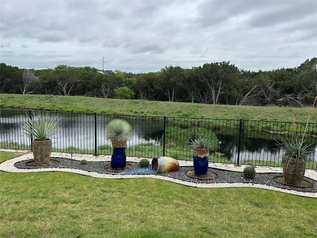 view of yard with a water view and fence