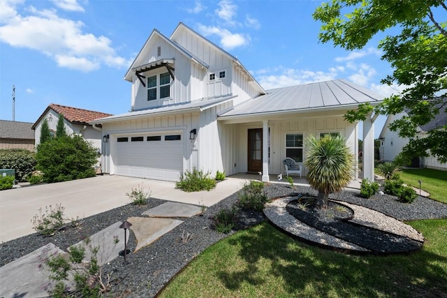 modern inspired farmhouse with an attached garage, board and batten siding, a porch, and concrete driveway