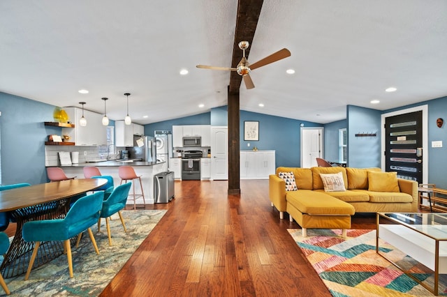 living room featuring dark hardwood / wood-style floors, vaulted ceiling with beams, and ceiling fan