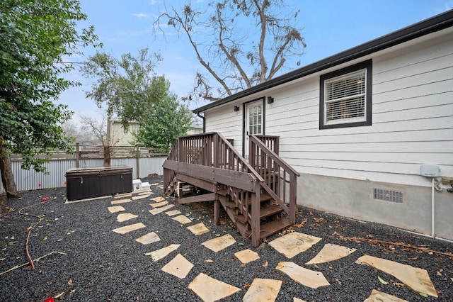 exterior space with a hot tub and a deck