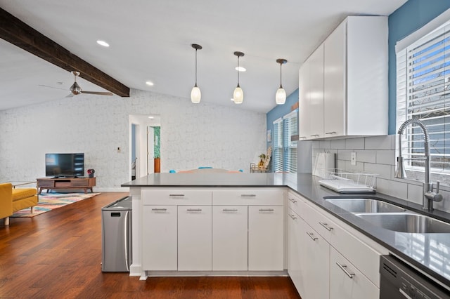 kitchen with white cabinetry, black dishwasher, sink, and kitchen peninsula