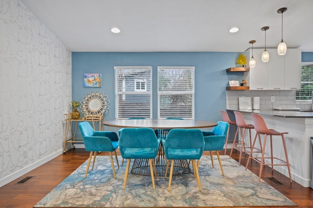 dining area with a wealth of natural light and dark wood-type flooring