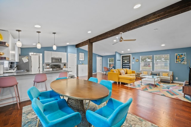 dining area featuring ceiling fan, dark hardwood / wood-style flooring, and lofted ceiling with beams