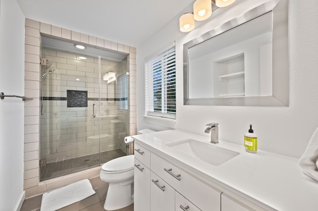 bathroom with vanity, a shower with shower door, and toilet