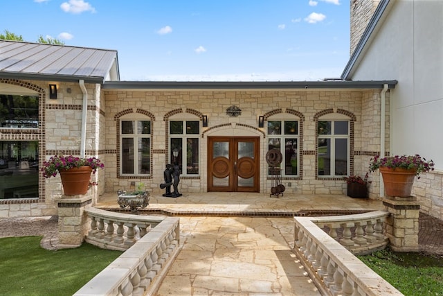 view of exterior entry featuring a patio area and french doors