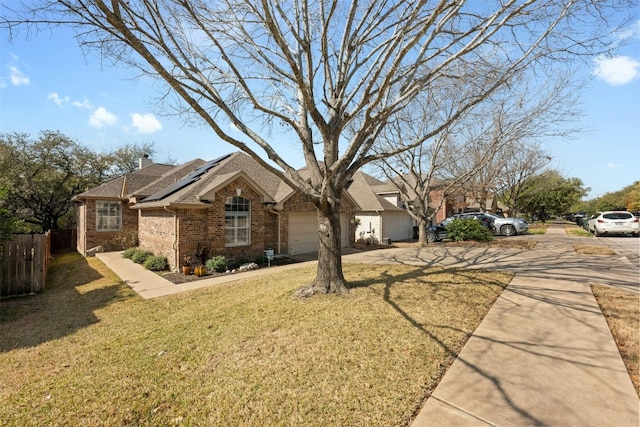 single story home with a garage, a front lawn, and solar panels