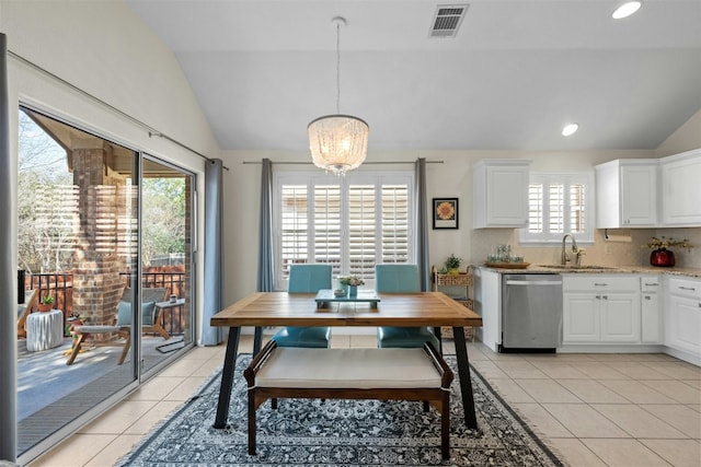 tiled dining area featuring lofted ceiling, sink, and a notable chandelier