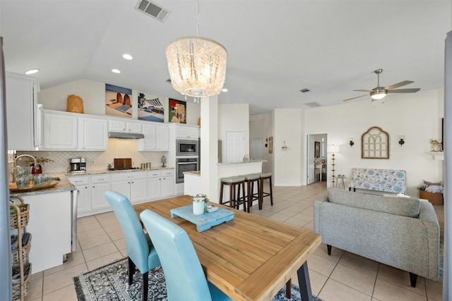 tiled dining area featuring lofted ceiling, sink, and ceiling fan with notable chandelier