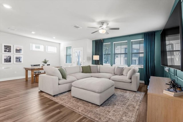 living room with ceiling fan, wood-type flooring, and a healthy amount of sunlight