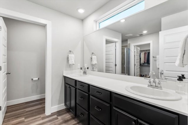 bathroom with hardwood / wood-style flooring, vanity, and a shower with door