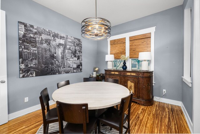 dining space with an inviting chandelier and light hardwood / wood-style floors