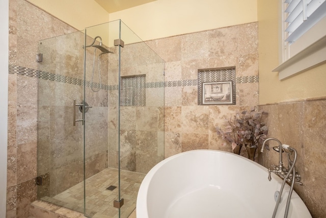 bathroom featuring independent shower and bath and tile walls