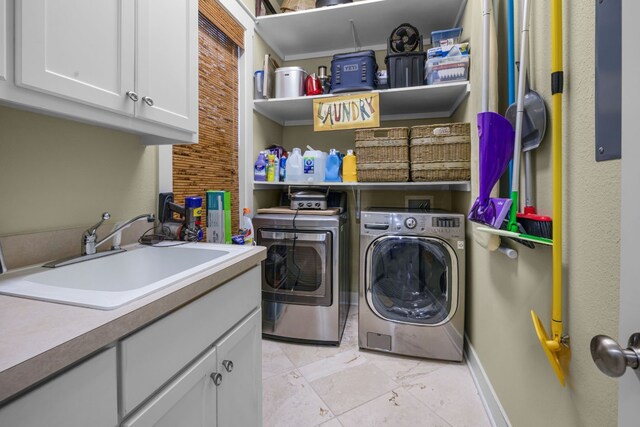 washroom with cabinets, separate washer and dryer, and sink