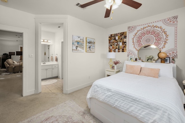 bedroom featuring ceiling fan, sink, light carpet, and ensuite bath