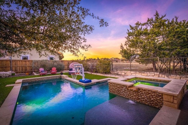 pool at dusk with an in ground hot tub