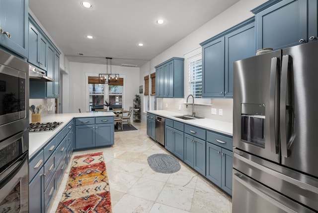 kitchen with blue cabinetry, sink, pendant lighting, stainless steel appliances, and decorative backsplash