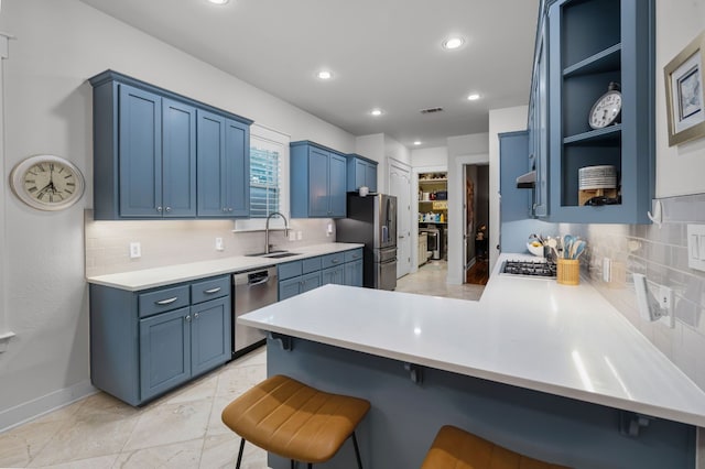 kitchen with blue cabinetry, stainless steel appliances, a kitchen breakfast bar, and kitchen peninsula