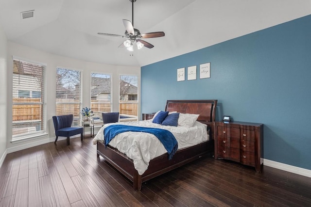 bedroom with a ceiling fan, wood finished floors, visible vents, baseboards, and vaulted ceiling