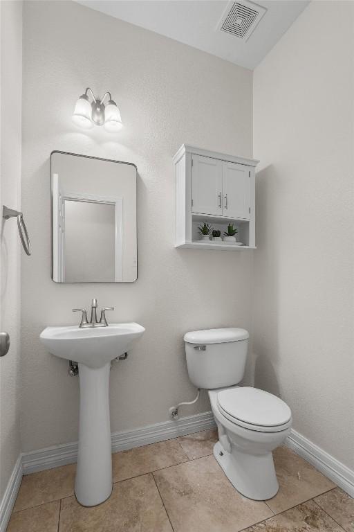 bathroom with visible vents, baseboards, toilet, and tile patterned flooring