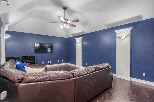 home theater room featuring ornate columns, lofted ceiling, dark wood-type flooring, and ceiling fan