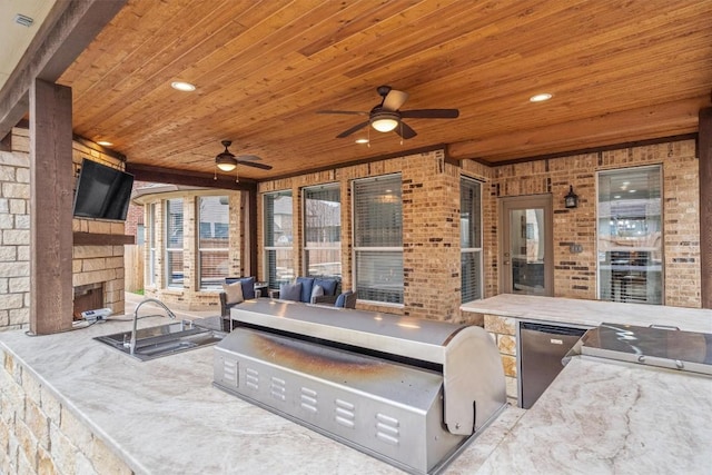 view of patio featuring a fireplace, ceiling fan, and exterior kitchen