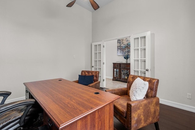 office with baseboards, french doors, a high ceiling, wood finished floors, and a ceiling fan